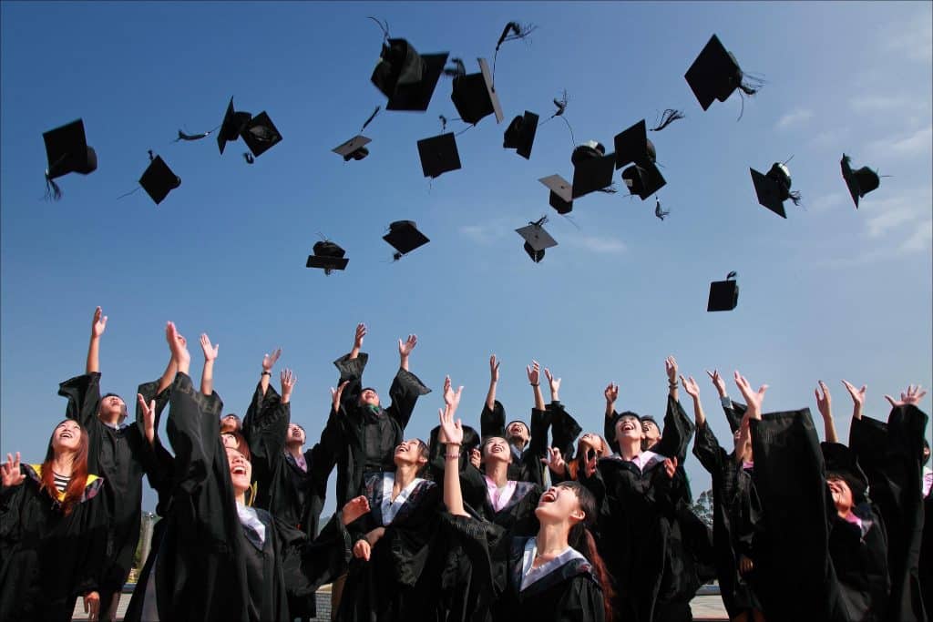 Graduates through their graduation caps.