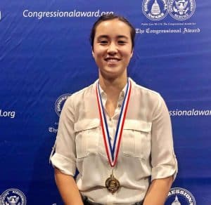 Student with her gold medal posing for a picture