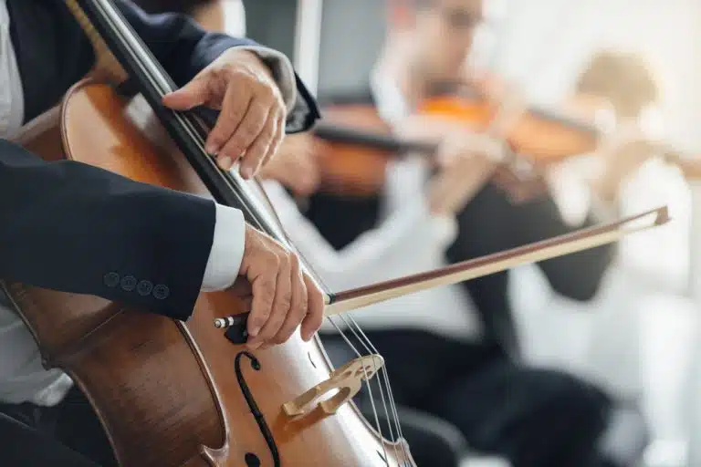 zoomed in picture of people playing the cello and violins