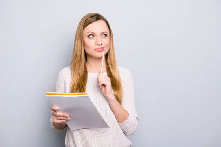 A woman holding a document and thinking