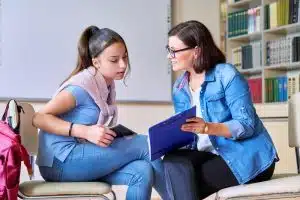 Young woman talking to a teacher.