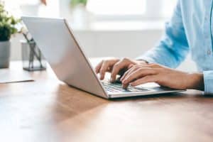 a student typing unto their laptop