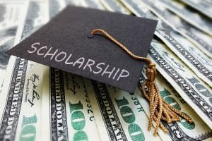 Scholarship word on a graduation cap on top of money