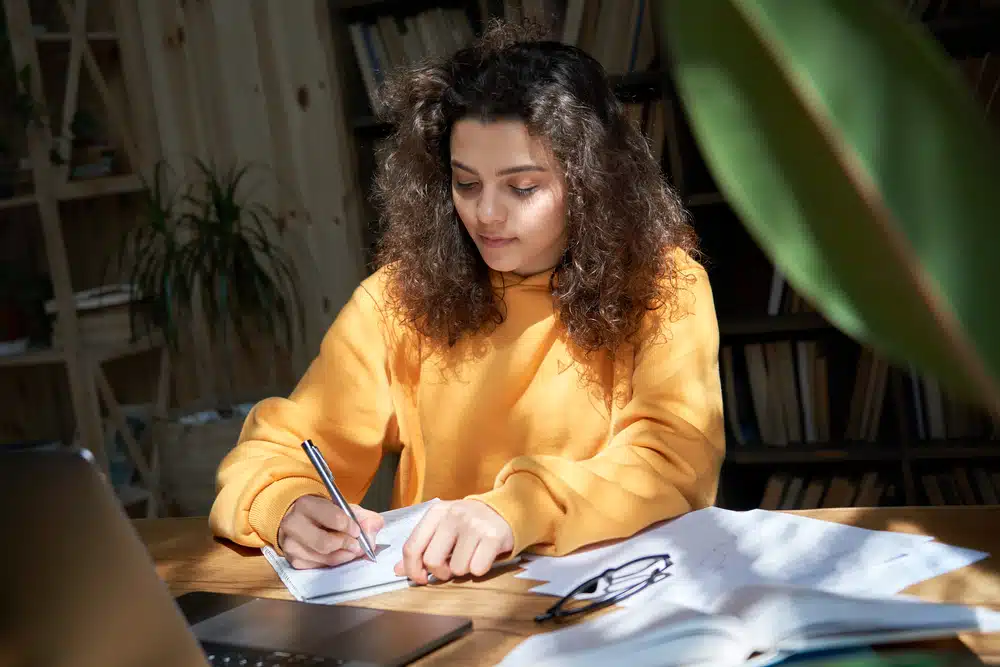 A teenage girl doing her homework at home.
