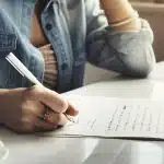 A woman writing a letter on a paper.