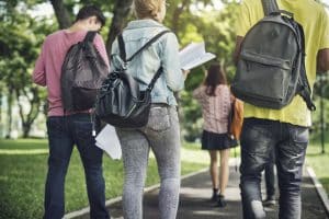 Four students walking with their backs facing the camera.