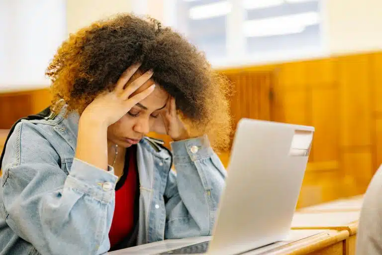 A frustrated student sitting in front of her laptop