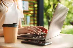 Female student typing in a laptop.