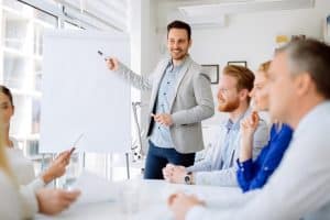 In front of his colleagues, a guy is doing a presentation