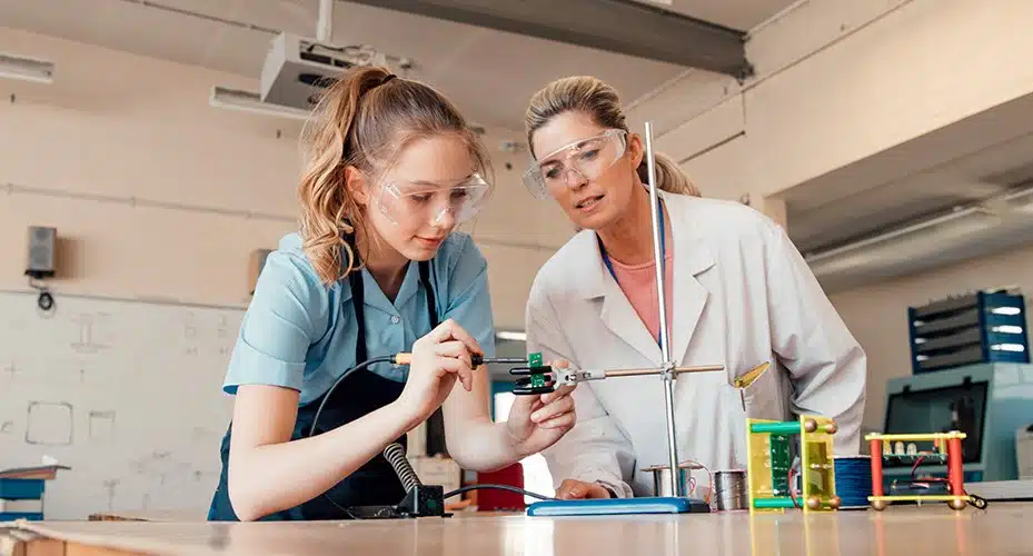 A teacher instructing a student in using an apparatus.