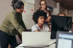 A team of programmers looking at the computer screen.