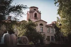 Pomona College building surrounded by tall trees at each side.