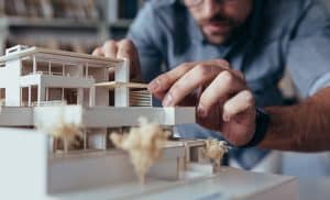 Close-up shot of an architect's hands making a house model.