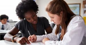 Female student being tutored by her teacher.