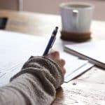 Writing an essay on a piece of paper.