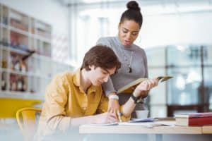 Young woman explaining an extracurricular activity to a student.