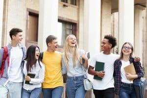 Group of student walking and laughing in front of a building.