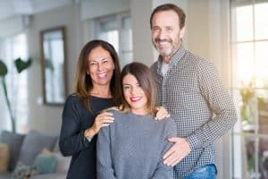 A teenager with her family smiling at the picture.