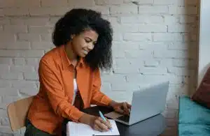 Young woman typing in a table.