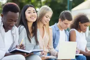 Students sitting on the bench while doing school work.