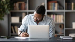 a student writing an essay inside a library