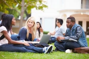 Group of University students lounging on the grass.