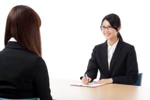 Female student facing her interviewer in a room.