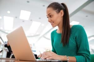 Female student typing in her laptop.