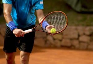 Unidentified male preparing to hit a ball during a tennis game.