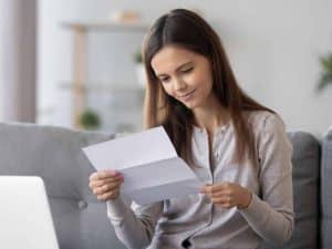 A student reading a letter while sitting.