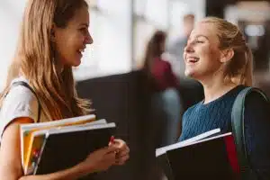 Two students talking in the hallway of the school.