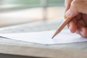 Using a pencil while writing in a desk.