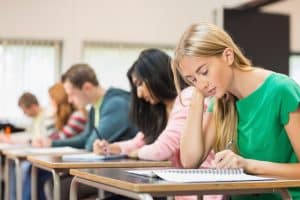 Group of Ivy League students taking an exam in a classroom.