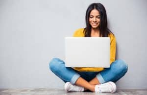 Young woman typing in the floor.