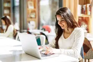 Young woman using a laptop in a desk.