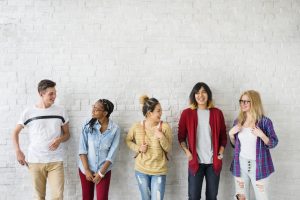 Group of students talking near a wall.