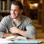 Young male student working on the library.