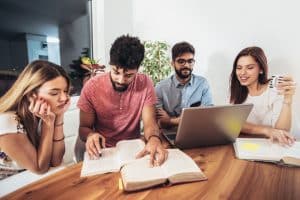 a group of four students with two male and two female studying together 