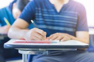 Unidentified student writing in his desk.