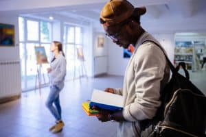 Male student reading in a Art gallery.