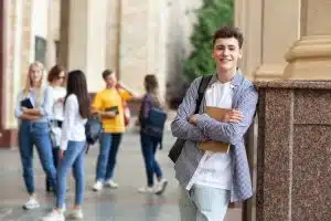 Young man smiling while on a hallway.