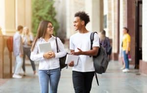 Two students walking in the hallway talking