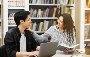 A woman talking to a student in a library.