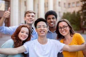 Students smiling for the camera in front of a building.