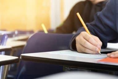 Student answering a text in a desk.