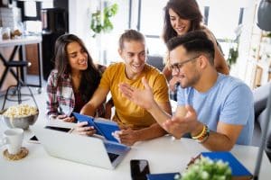 College students gathered around a table while talking.