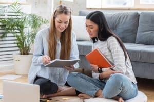 Two female students studying in a living room.