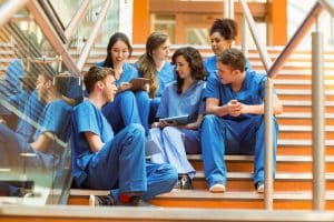 group of medical students sitting and communing at a stair outside of a medical college