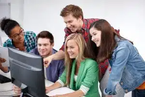 Students looking at the computer while studying together