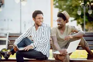 Two students talking in a bench.